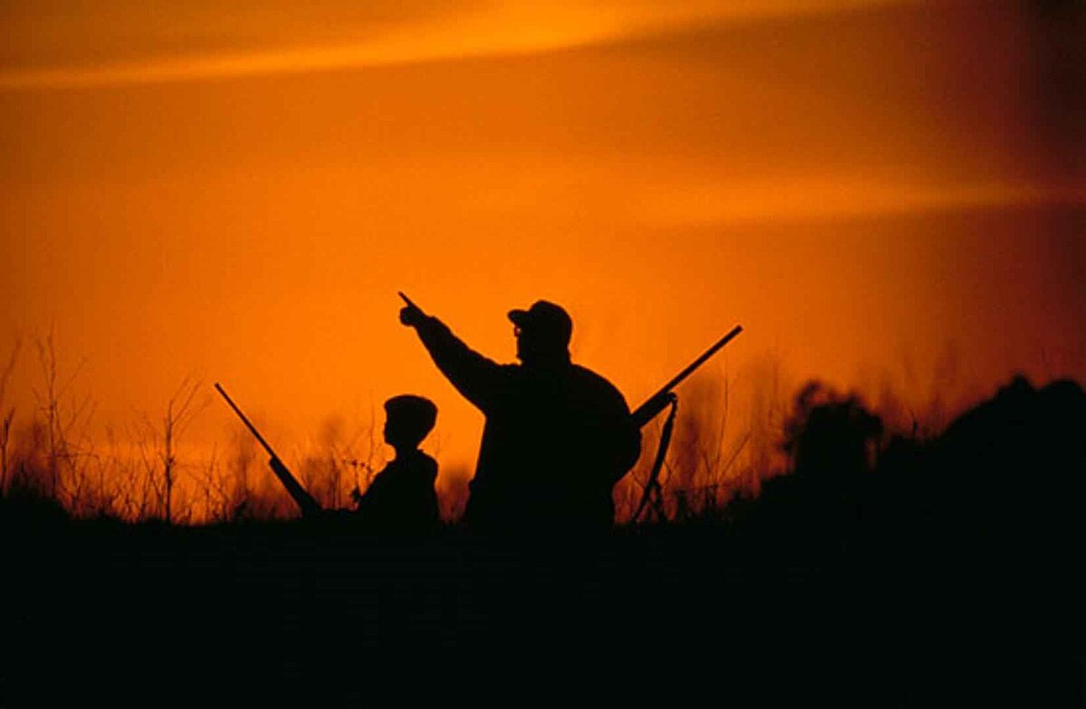 father son hunting in the sunset
